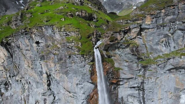Aerial slow motion: drone flying over scenic high waterfall, mountain stream falling from tall rocky cliff on the italian Alps. Pis waterfall near Torino, Piedmont, Italy
