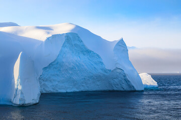 Fototapeta na wymiar Huge iceberg, evening light, clearing mist, Bransfield Strait, near South Shetland Islands and Antarctic Peninsula, Antarctica
