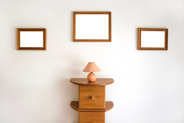 Empty wooden frames on a wall with a commode