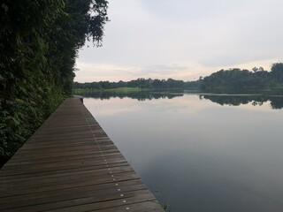 Wooden boardwalk trail close to water reservoir in Singapore 