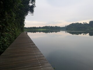 Fototapeta premium Wooden boardwalk trail close to water reservoir in Singapore 