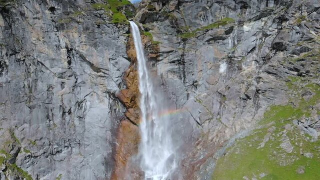 Aerial slow motion: drone flying over scenic high waterfall, mountain stream falling from tall rocky cliff on the italian Alps. Pis waterfall near Torino, Piedmont, Italy