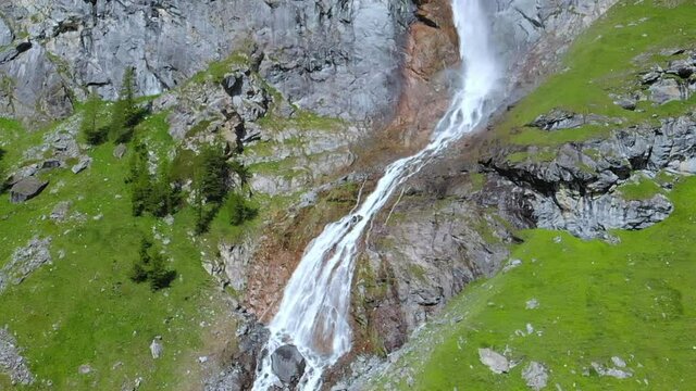 Aerial slow motion: drone flying over scenic high waterfall, mountain stream falling from tall rocky cliff on the italian Alps. Pis waterfall near Torino, Piedmont, Italy