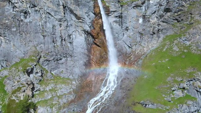 Aerial slow motion: drone flying over scenic high waterfall, mountain stream falling from tall rocky cliff on the italian Alps. Pis waterfall near Torino, Piedmont, Italy
