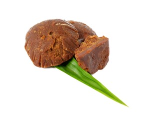 Organic brown palm sugar or coconut sugar, better known as Java sugar, sugar made from coconut juice with fresh green pandan leaves. Isolated on a white background