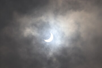 Obraz na płótnie Canvas Full and partial Solar Eclipse seen in the cloudy sky.