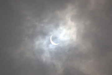 Obraz na płótnie Canvas Full Solar Eclipse seen in the cloudy sky.