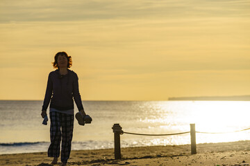 Fototapeta premium Woman walking on beach at morning.