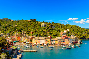 Fototapeta na wymiar It's Panoramic view of Portofino, is an Italian fishing village, Genoa province, Italy. A vacation resort with a picturesque harbour and with celebrity and artistic visitors.