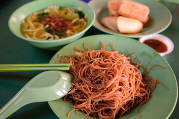 Popular local breakfast delights in Singapore — fried bee hoon, noodle soup, and fried snacks....