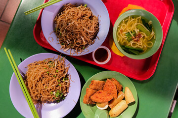 Popular local breakfast delights in Singapore — fried bee hoon, noodle soup, and fried snacks....