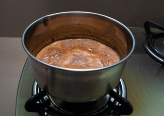 hot boiling chai, tea in a round vessel on stove