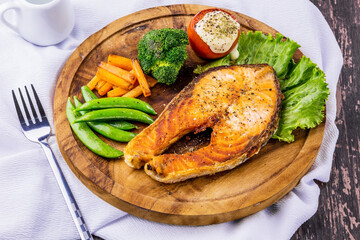 Salmon steak on wooden plate