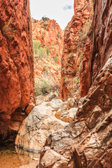 Landscape along Standley Chasm track to Standley Chasm Gorge and the famous Larapinta Trail in the West MacDonnell Ranges during the Australian summer with fantastic green plants and red rocks