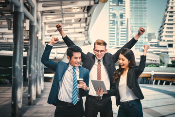 Portrait of Business team raising arms celebrate on blurred city background. Business success concept.