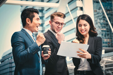 Portrait of Business team raising arms celebrate on blurred city background. Business success concept.