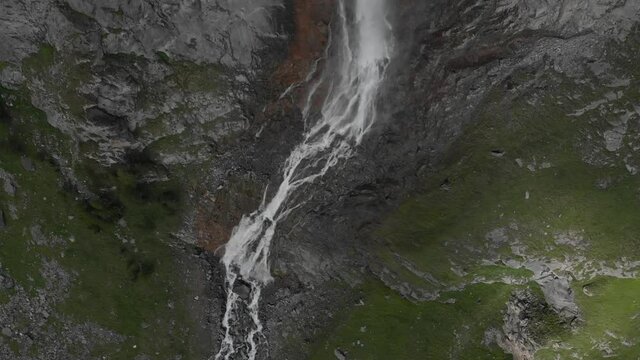 Aerial: drone flying over scenic high waterfall, mountain stream falling from tall rocky cliff on the italian Alps. Pis waterfall near Torino, Piedmont, Italy. Native d-log color profile