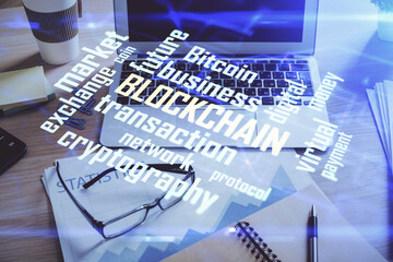 Double exposure of blockchain and crypto economy theme hologram and table with computer background....