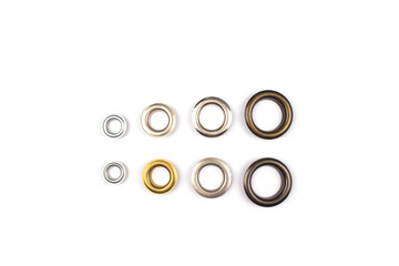 Set of brass multicoloured metal eyelets or rivets - curtains rings for fastening fabric to the cornice, isolated on white. With copyspace for text for your presentation © Iryna Mylinska