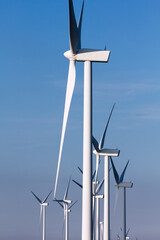 Pico Gallo, Tineo, Asturias. Vertical view of wind mill park at summer with pale blue sky. - obrazy, fototapety, plakaty