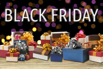 Black Friday. Many gift boxes on wooden table against blurred lights
