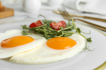 Tasty fried eggs with tomato and sprouts on plate, closeup