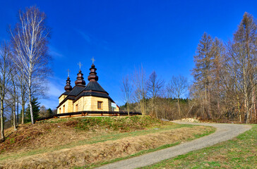 Orthodox wooden church in Kunkowa village near Gorlice in sunny spring day, Low Beskids (Beskid Niski), Poland 
