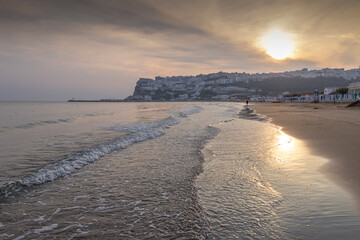 Panoramic view of the bay of Peschici at sunrise: the old town and the sandy beach, Italy (Apulia). Peschici is famous for its seaside resorts, its territory belongs to the Gargano National Park.