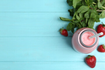 Tasty strawberry smoothie and mint on light blue wooden table, flat lay. Space for text
