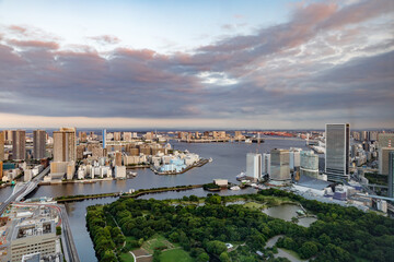 東京の水辺に建つビル群と夕焼けの空