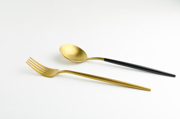 Golden spoon and fork in a tableware
