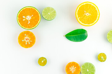 a mix of citrus fruits with leaves in a white background, top view