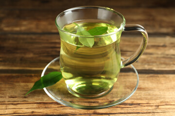 Cup of aromatic green tea on wooden table