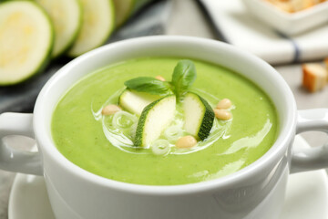 Tasty homemade zucchini cream soup in bowl, closeup