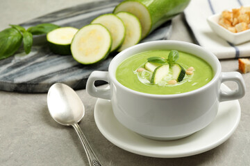 Tasty homemade zucchini cream soup served on grey table