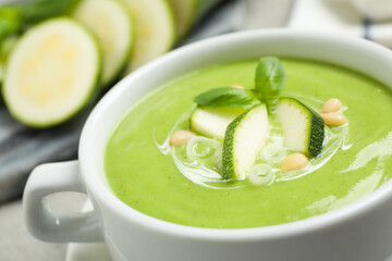 Tasty homemade zucchini cream soup in bowl, closeup