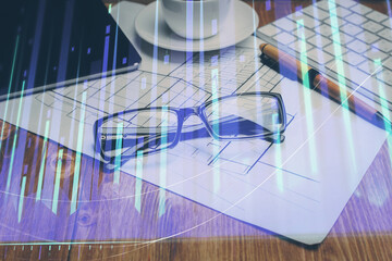 Financial chart hologram with glasses on the table background. Concept of business. Double exposure.