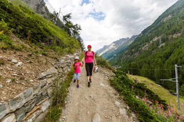 Fototapeta na wymiar Hikers with backpack looking at mountains, alpine view, mother with child