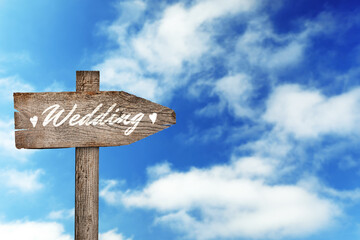 Wooden plaque with inscription Wedding against beautiful blue sky, space for text