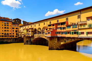 It's Ponte Vecchio (Old Bridge), a Medieval stone closed-spandrel segmental arch bridge over the Arno River, in Florence, Italy.