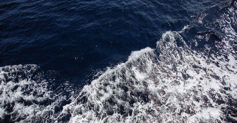 Blue sea water with white foam for background