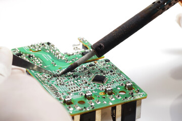 Close up shoot of catching a small electronic component with a sharp pointed tweezers