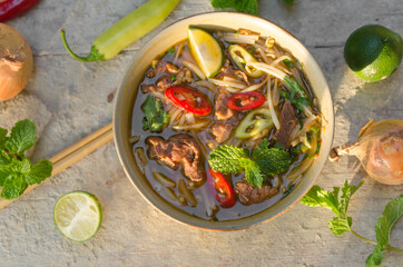 Pho Bo - Vietnamese fresh rice noodle soup with beef, herbs and chili. Vietnam's national dish.