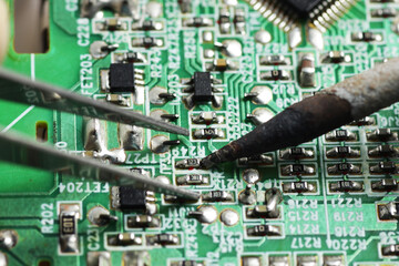 Close up shoot of catching a small electronic component with a sharp pointed tweezers