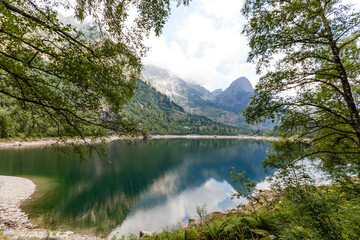 Fototapeta na wymiar alpine high mountain lake, coniferous woods are reflected in the water, Antrona valley Campliccioli lake, Italy Piedmont