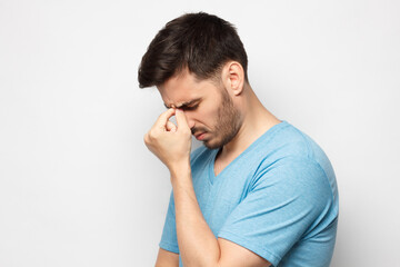 Face palm concept. Stressed out young guy making facepalm gesture with hand, isolated on gray...