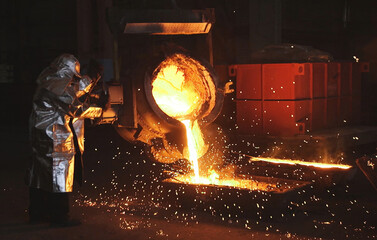 Smelting orange metal in a metallurgical plant. Liquid iron