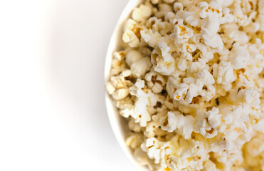 Popcorn on a white plate. A light, delicious snack. Corn products.