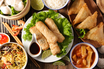 selection of asian food- spring roll, samosa, dumpling, noodles
