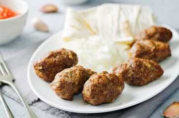 Minced meat sausage with onion, sour cream, pita and red bell pepper relish
